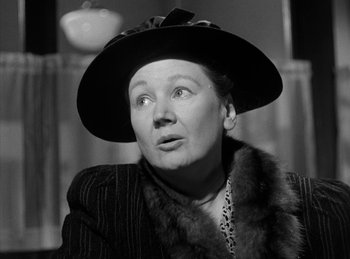 Movie still from “The Killers” (1946), directed by Robert Siodmak – An older woman wearing a black hat and a fur stole; Close Up shot, Low angle
