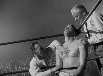 Movie still from “The Killers” (1946), directed by Robert Siodmak – An old black and white photo of a man in a boxing ring; Medium shot, Low angle