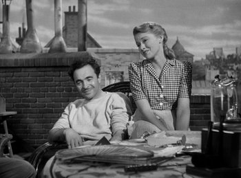 Movie still from “The Killers” (1946), directed by Robert Siodmak – A man and a woman sitting at an outdoor table; Medium shot, Low angle