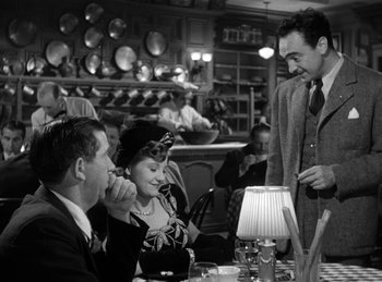 Movie still from “The Killers” (1946), directed by Robert Siodmak – An old photo of people sitting at a table in a restaurant; Medium shot, Over the shoulder angle