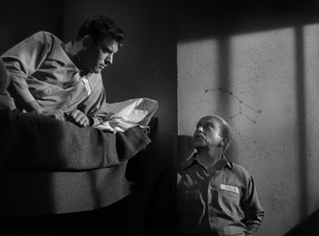 Movie still from “The Killers” (1946), directed by Robert Siodmak – Two men are standing next to each other in a room; Wide shot, Low angle