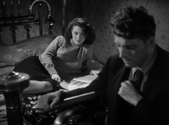 Movie still from “The Killers” (1946), directed by Robert Siodmak – A man and a woman sitting on a couch; Medium shot, High angle