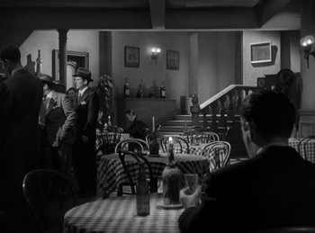 Movie still from “The Killers” (1946), directed by Robert Siodmak – A black and white photo of people sitting at tables in a restaurant; Wide shot, High angle