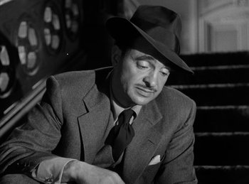 Movie still from “The Killers” (1946), directed by Robert Siodmak – A man in a suit and hat looking at his watch; Close Up shot, Low angle