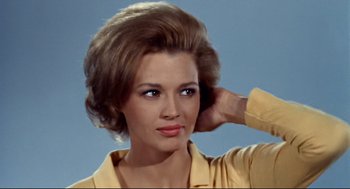 Movie still from “The Killers” (1964), directed by Don Siegel – A beautiful woman with brown hair wearing a yellow shirt; Close Up shot, Low angle