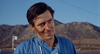 Movie still from “The Killers” (1964), directed by Don Siegel – A person wearing a blue shirt; Close Up shot, Low angle