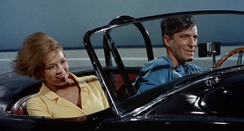 Movie still from “The Killers” (1964), directed by Don Siegel – A man and a woman sitting in the back seat of a car; Medium shot, Low angle