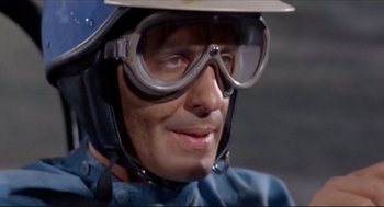Movie still from “The Killers” (1964), directed by Don Siegel – A person wearing goggles and a helmet; Close Up shot, Low angle