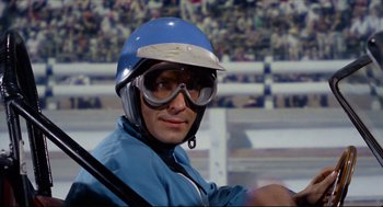 Movie still from “The Killers” (1964), directed by Don Siegel – A man wearing a helmet , goggles , and a blue jacket; Close Up shot, Low angle