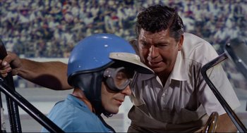 Movie still from “The Killers” (1964), directed by Don Siegel – A man and a man in a motorcycle helmet; Close Up shot, Low angle