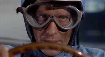 Movie still from “The Killers” (1964), directed by Don Siegel – A person wearing goggles and a helmet; Close Up shot, Low angle
