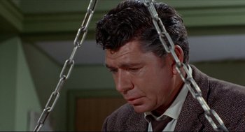 Movie still from “The Killers” (1964), directed by Don Siegel – A person wearing a suit and tie; Close Up shot, High angle