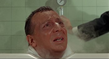 Movie still from “The Killers” (1964), directed by Don Siegel – An older man in a bathtub with a thermometer in the background; Close Up shot, High angle
