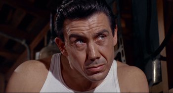 Movie still from “The Killers” (1964), directed by Don Siegel – A person wearing a tank top; Close Up shot, Low angle