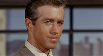 Movie still from “The Killers” (1964), directed by Don Siegel – A person wearing a suit and tie; Close Up shot, Over the shoulder angle
