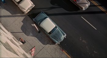 Movie still from “The Killers” (1964), directed by Don Siegel – An aerial view of a car on the street; Extreme Wide shot, Overhead angle