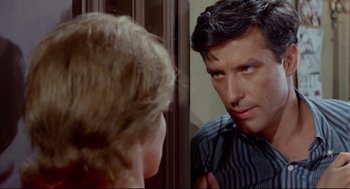 Movie still from “The Killers” (1964), directed by Don Siegel – A man looking in the mirror while a woman looks on; Close Up shot, Over the shoulder angle
