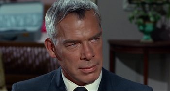 Movie still from “The Killers” (1964), directed by Don Siegel – An older man in a black suit and white tie; Close Up shot, Over the shoulder angle