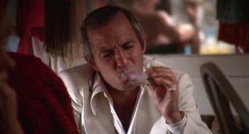 Movie still from “The Killing of a Chinese Bookie” (1976), directed by John Cassavetes – A man smoking a cigarette while wearing a white shirt; Close Up shot, Low angle