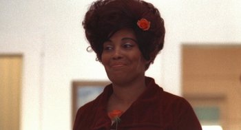 Movie still from “The Killing of a Chinese Bookie” (1976), directed by John Cassavetes – An older woman with a flower in her hair; Close Up shot, Over the shoulder angle