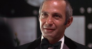 Movie still from “The Killing of a Chinese Bookie” (1976), directed by John Cassavetes – An older man wearing a black suit and a bow tie; Close Up shot, Low angle