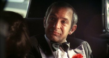 Movie still from “The Killing of a Chinese Bookie” (1976), directed by John Cassavetes – A person wearing a suit and a bow tie; Close Up shot, Over the shoulder angle