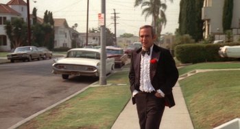 Movie still from “The Killing of a Chinese Bookie” (1976), directed by John Cassavetes – A man in a tuxedo walking down the street; Wide shot, Low angle