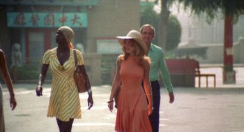 Movie still from “The Killing of a Chinese Bookie” (1976), directed by John Cassavetes – A group of people walking down a street; Medium shot, High angle