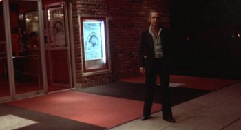 Movie still from “The Killing of a Chinese Bookie” (1976), directed by John Cassavetes – A man standing in front of a brick wall; Wide shot, Low angle