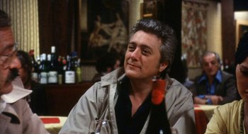 Movie still from “The Killing of a Chinese Bookie” (1976), directed by John Cassavetes – An older man sitting at a table in a restaurant; Close Up shot, Over the shoulder angle