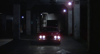Movie still from “The Killing of a Chinese Bookie” (1976), directed by John Cassavetes – A red car parked in a parking garage at night; Extreme Wide shot, High angle