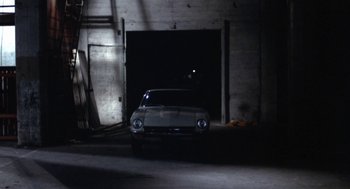 Movie still from “The Killing of a Chinese Bookie” (1976), directed by John Cassavetes – A car parked in front of a garage door; Wide shot, High angle