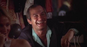 Movie still from “The Killing of a Chinese Bookie” (1976), directed by John Cassavetes – A man smiling with his mouth wide open; Close Up shot, Low angle