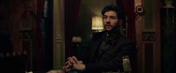 Movie still from “The Kindness of Strangers” (2019), directed by Lone Scherfig – A man sitting at a table in front of a window; Medium shot, Over the shoulder angle