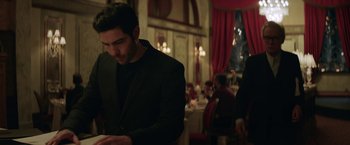 Movie still from “The Kindness of Strangers” (2019), directed by Lone Scherfig – A man in a black jacket is looking at his cell phone; Medium shot, Over the shoulder angle
