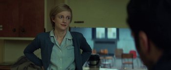 Movie still from “The Kindness of Strangers” (2019), directed by Lone Scherfig – A woman standing in front of a table in a room; Medium shot, Low angle