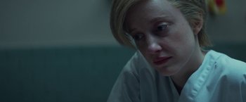 Movie still from “The Kindness of Strangers” (2019), directed by Lone Scherfig – A woman sitting in front of a wall looking sad; Close Up shot, High angle