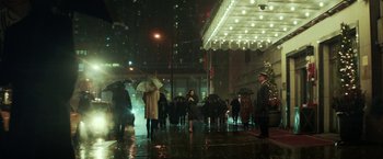 Movie still from “The Kindness of Strangers” (2019), directed by Lone Scherfig – A group of people walking down a street at night with umbrellas; Extreme Wide shot, Low angle