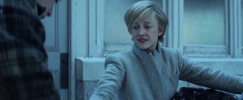 Movie still from “The Kindness of Strangers” (2019), directed by Lone Scherfig – A woman in a gray coat is looking down; Close Up shot, High angle