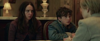Movie still from “The Kindness of Strangers” (2019), directed by Lone Scherfig – Two people sitting at a table in front of a lamp; Close Up shot, Over the shoulder angle