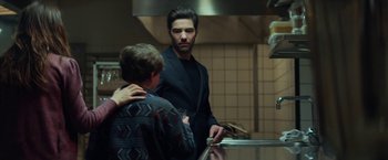Movie still from “The Kindness of Strangers” (2019), directed by Lone Scherfig – A man standing next to another man in a kitchen; Medium shot, Over the shoulder angle