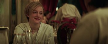 Movie still from “The Kindness of Strangers” (2019), directed by Lone Scherfig – A woman sitting in front of a vase of flowers; Close Up shot, Over the shoulder angle