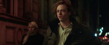 Movie still from “The Kindness of Strangers” (2019), directed by Lone Scherfig – A man with long hair and a jacket on; Close Up shot, Low angle