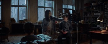 Movie still from “The Kindness of Strangers” (2019), directed by Lone Scherfig – Two people sitting in a room with a window in the background; Medium shot, Over the shoulder angle