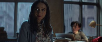 Movie still from “The Kindness of Strangers” (2019), directed by Lone Scherfig – A woman sitting in front of a table with a laptop; Medium shot, Over the shoulder angle