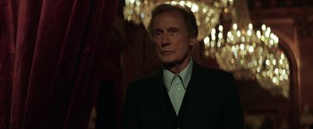 Movie still from “The Kindness of Strangers” (2019), directed by Lone Scherfig – An older man wearing a suit and tie; Medium shot, Low angle