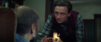 Movie still from “The Kindness of Strangers” (2019), directed by Lone Scherfig – A man looking at himself in the mirror while holding a lit candle; Close Up shot, Over the shoulder angle