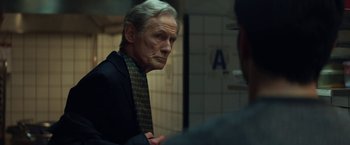 Movie still from “The Kindness of Strangers” (2019), directed by Lone Scherfig – An older man wearing a suit and a tie; Close Up shot, Over the shoulder angle