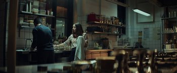 Movie still from “The Kindness of Strangers” (2019), directed by Lone Scherfig – A woman sitting in a kitchen holding a plate; Medium shot, Over the shoulder angle