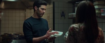 Movie still from “The Kindness of Strangers” (2019), directed by Lone Scherfig – A man holding a napkin in his hands; Medium shot, Over the shoulder angle